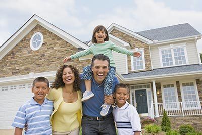 A Happy Family in Front of Their House — Miami, FL — American Quality Assurance Group