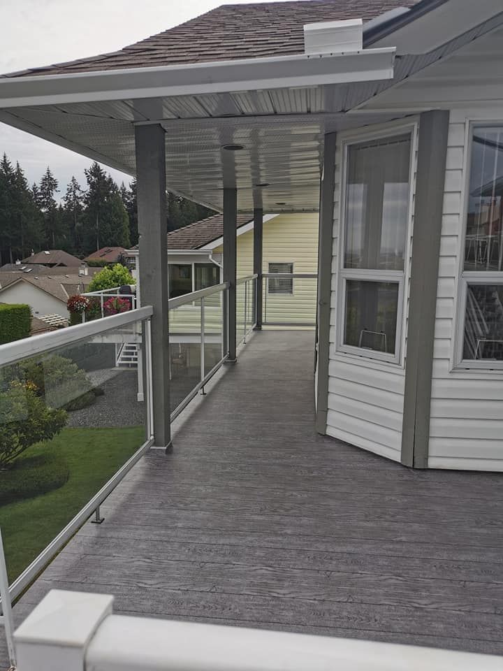 A walkway leading to a house with a glass railing.