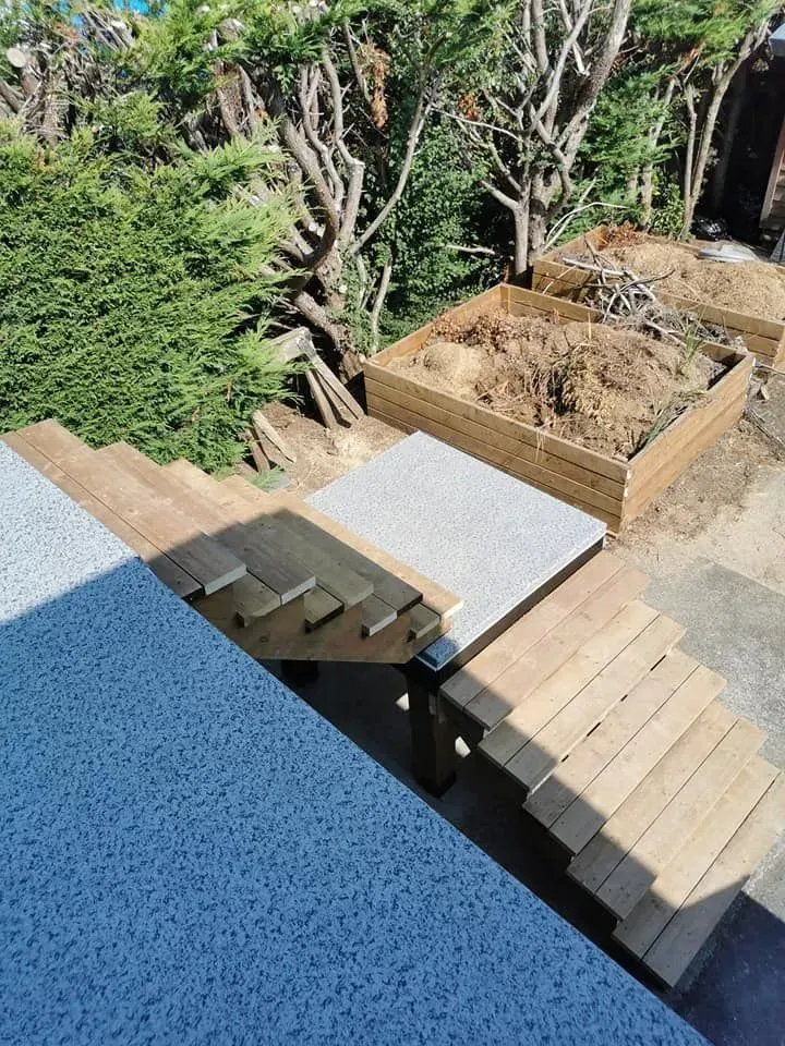 A wooden staircase is being built in a backyard.