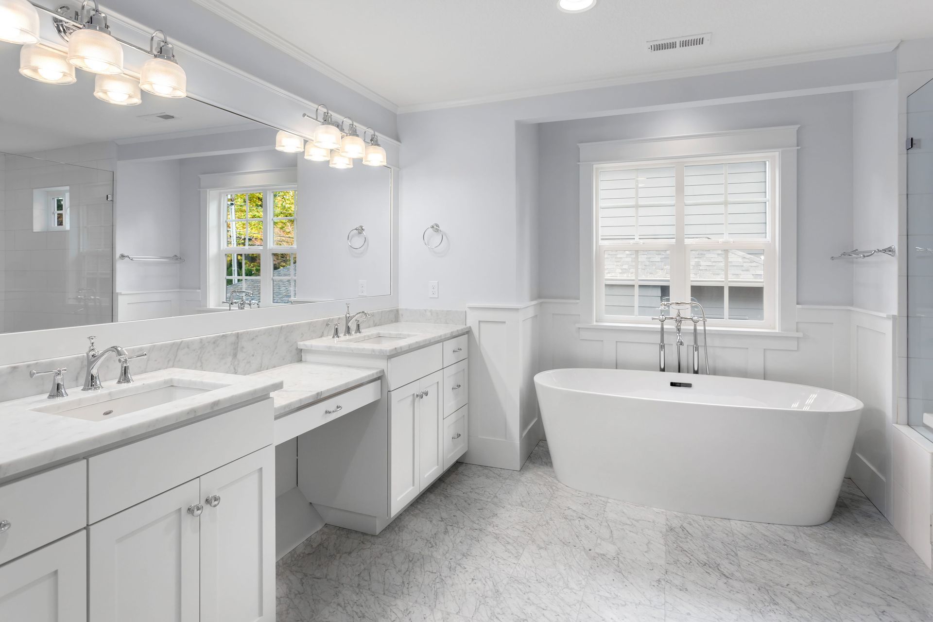 A bathroom with two sinks, a tub, and a large mirror.