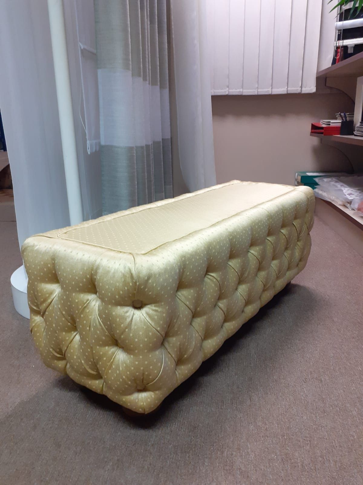 Pouf rettangolare trapuntato in tessuto dorato con piccoli pois bianchi.