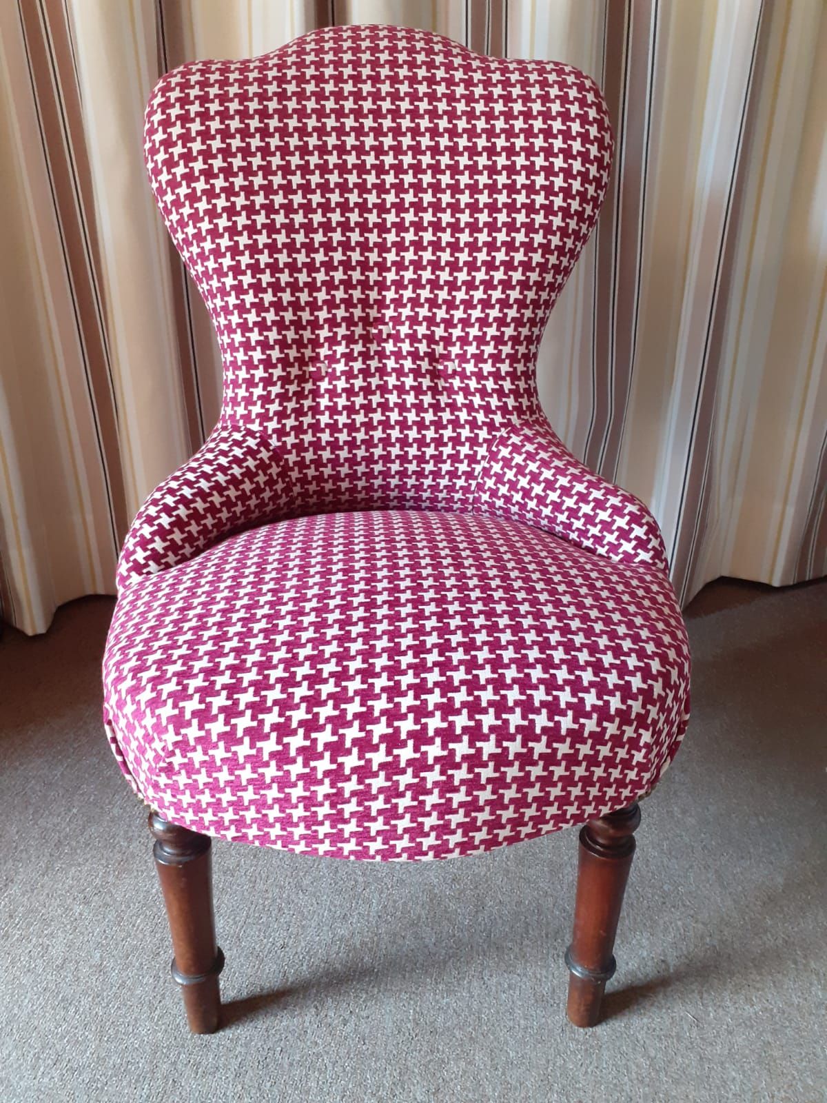 Sedia antica imbottita con tessuto pied de poule rosso scuro e bianco, schienale decorato e gambe in legno tornito.