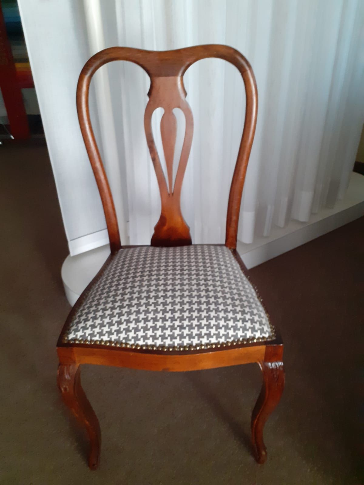 Sedia in legno con seduta decorata e schienale curvo.