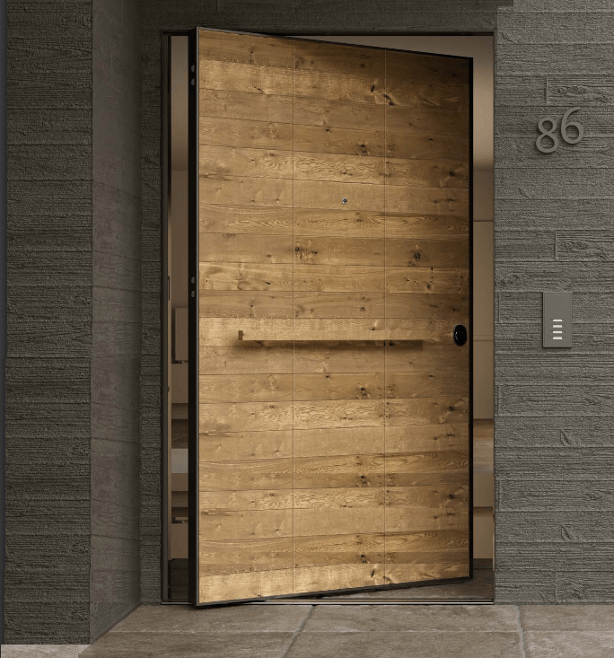 Una porta d'ingresso in legno socchiusa si trova nell'atrio di un edificio grigio, con il numero civico 86 accanto.