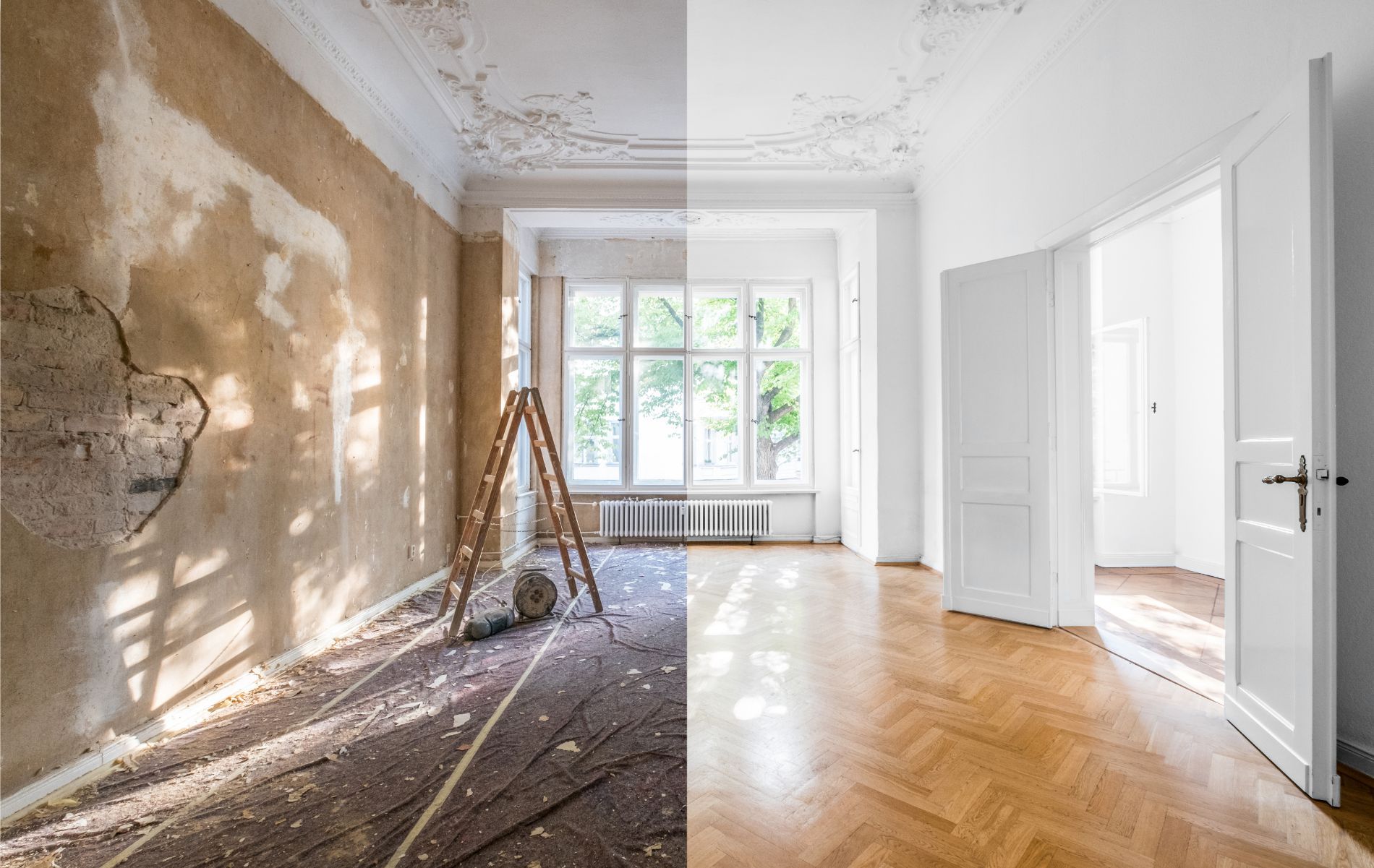 Stanza vuota ristrutturata con parete non rifinita, pavimento in legno e finestre luminose in fondo.