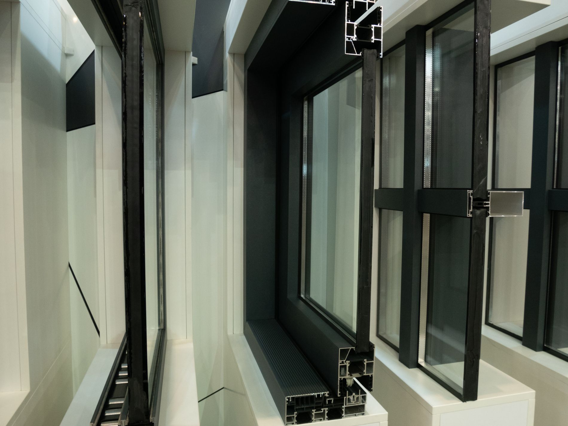Interno di un edificio moderno con finestre alte e pannelli di vetro con cornice nera.