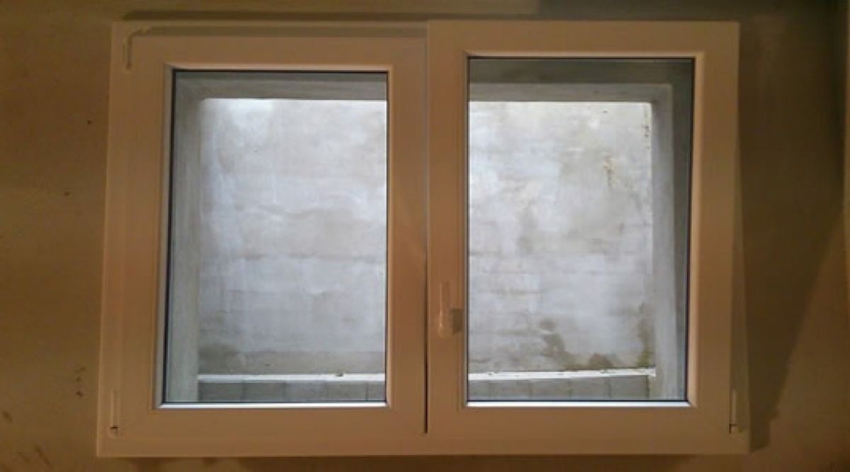 Finestra a due ante con vetro satinato in una parete beige