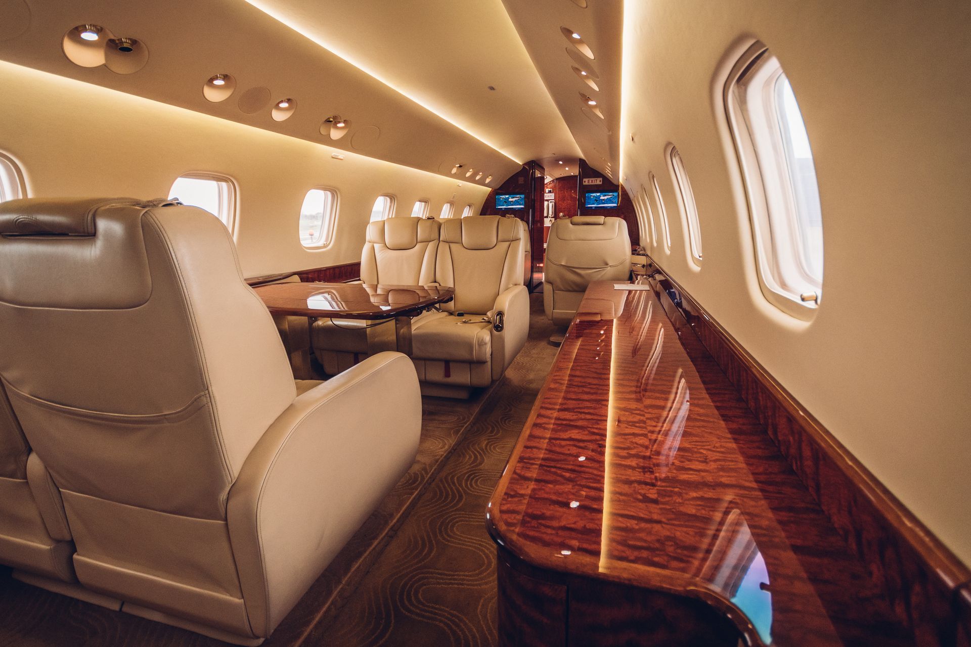 The inside of a private jet with a table and chairs.