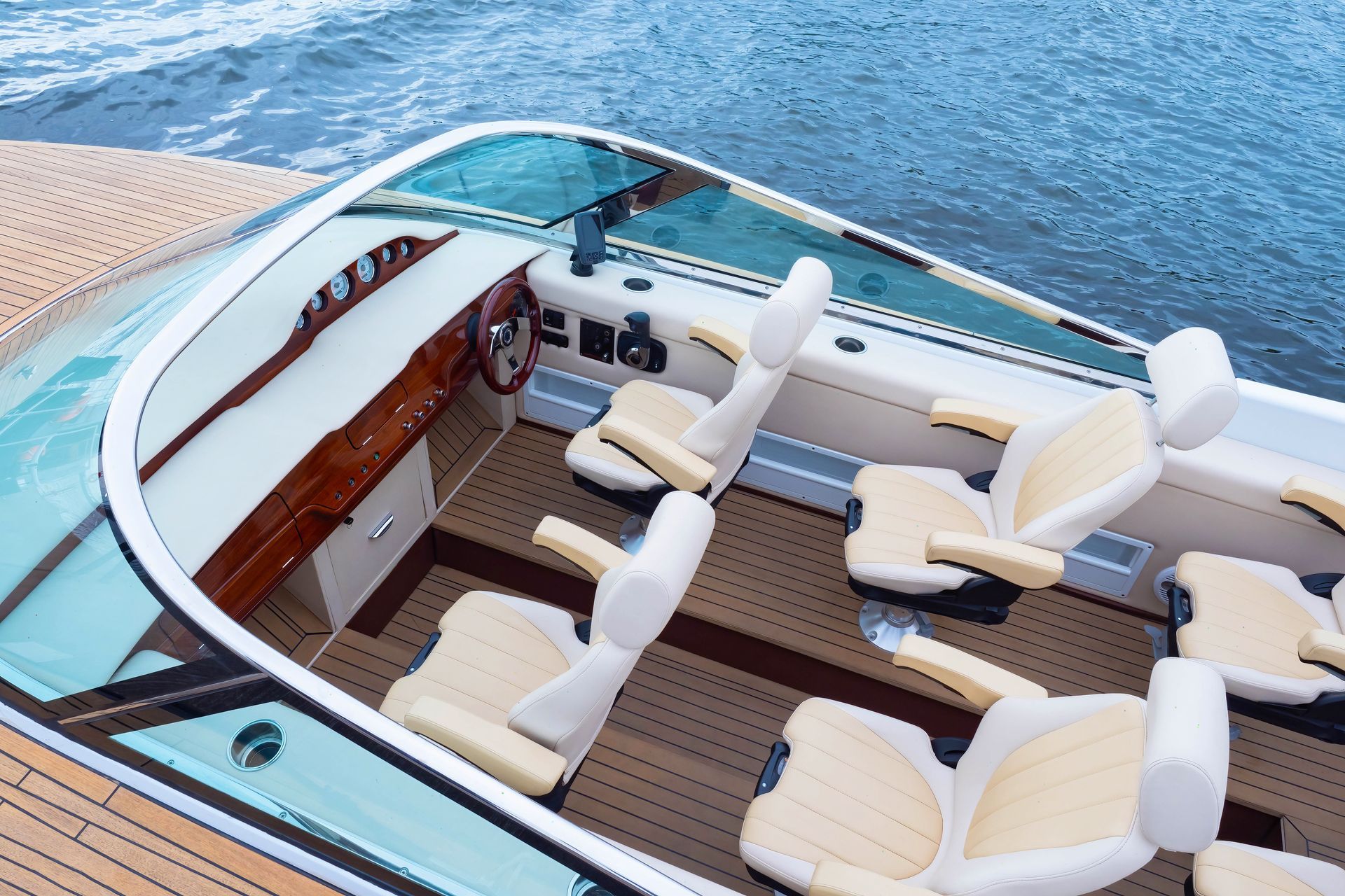 The inside of a boat with a lot of seats and a steering wheel
