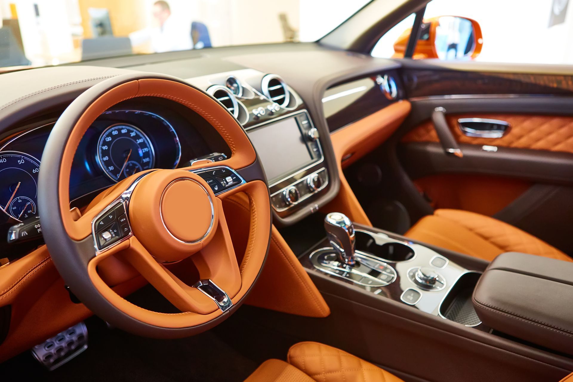 The interior of a car with brown leather seats and a steering wheel.