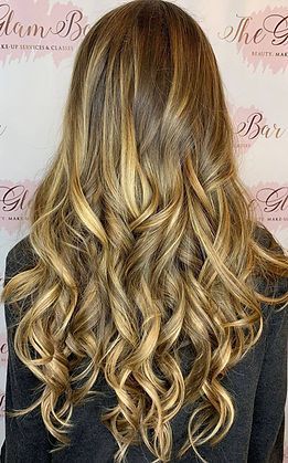 The back of a woman 's head with long curly hair.