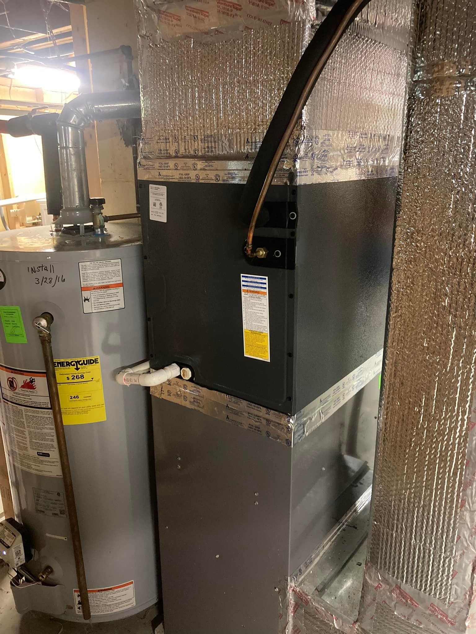 Water heater and HVAC furnace in a utility closet with insulated ductwork and pipes.