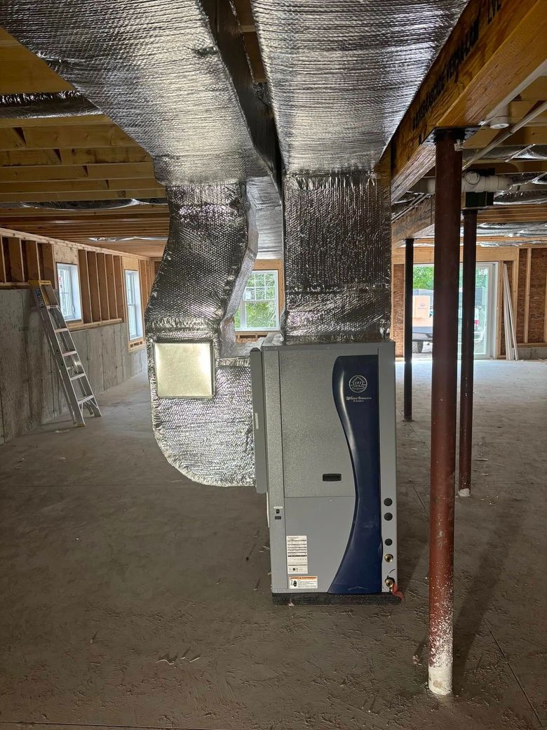 Unfinished basement with exposed insulation, ducts, support posts, and a standing HVAC unit