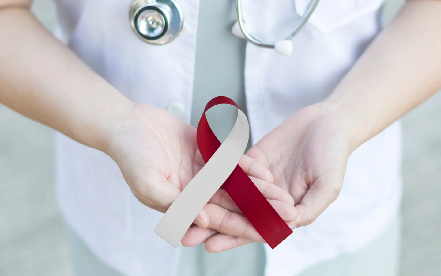 Get oral cancer screenings at Morgantown WV's best family dentist. A doctor is holding a red and white ribbon in her hands.