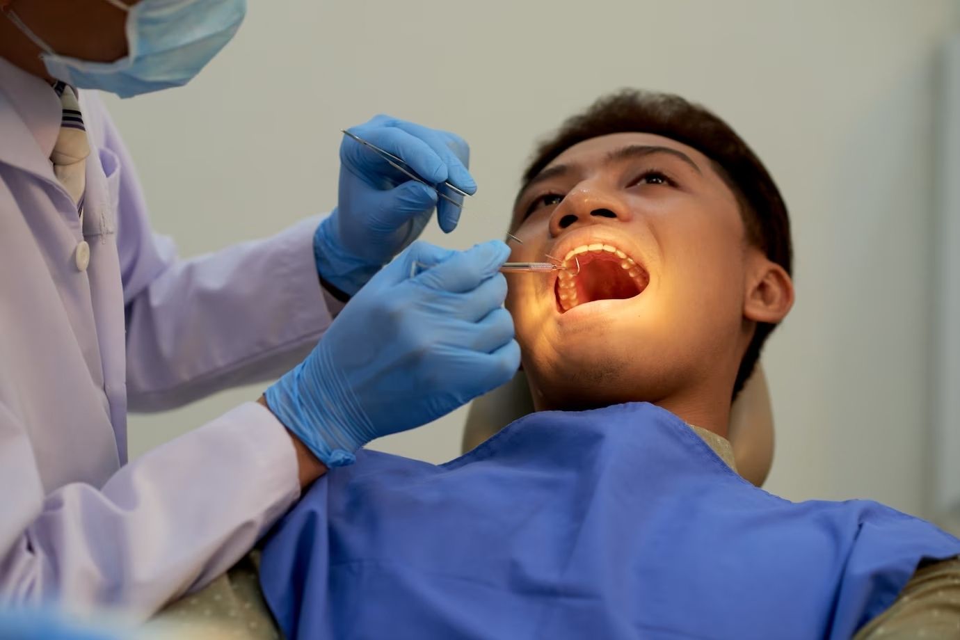 A man is getting his teeth examined by a dentist.