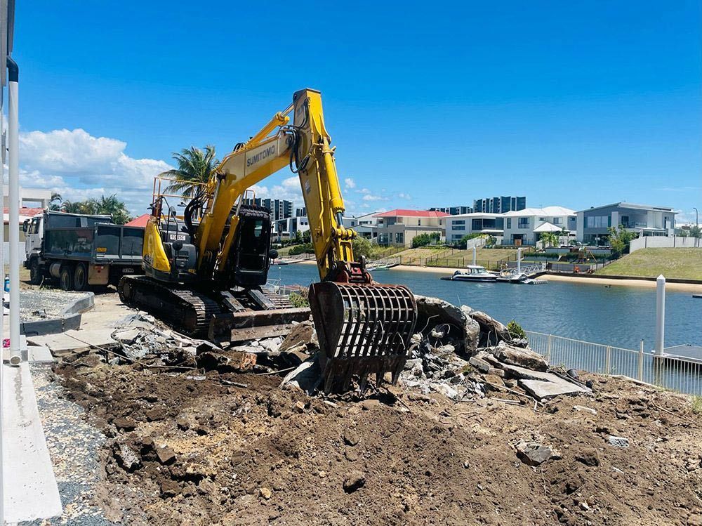 A Bulldozer Is Digging a Hole in The Ground — Lifestyle Demolition In Ballina, NSW