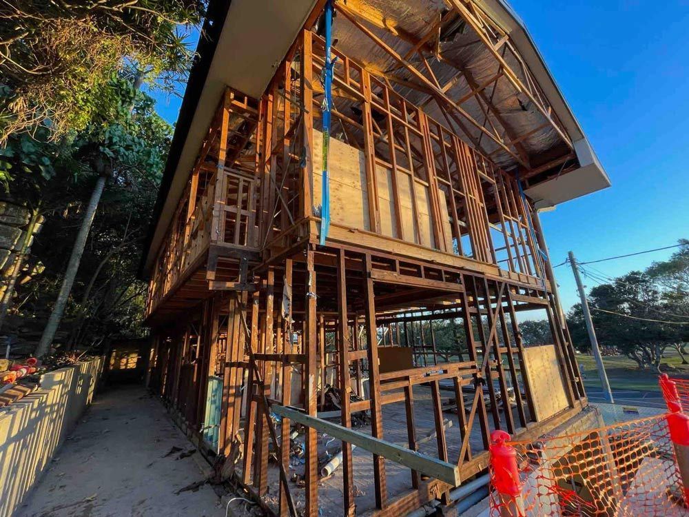 A Large Yellow Excavator Is Destroying a Building on A Construction Site — Lifestyle Demolition In Murwillumbah, NSW
