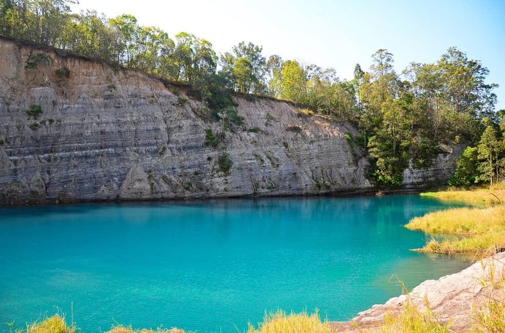 Bright Blue Water In A Quarry Surrounded By A Rocky Cliff — Lifestyle Contaminated Soil In Lismore, NSW