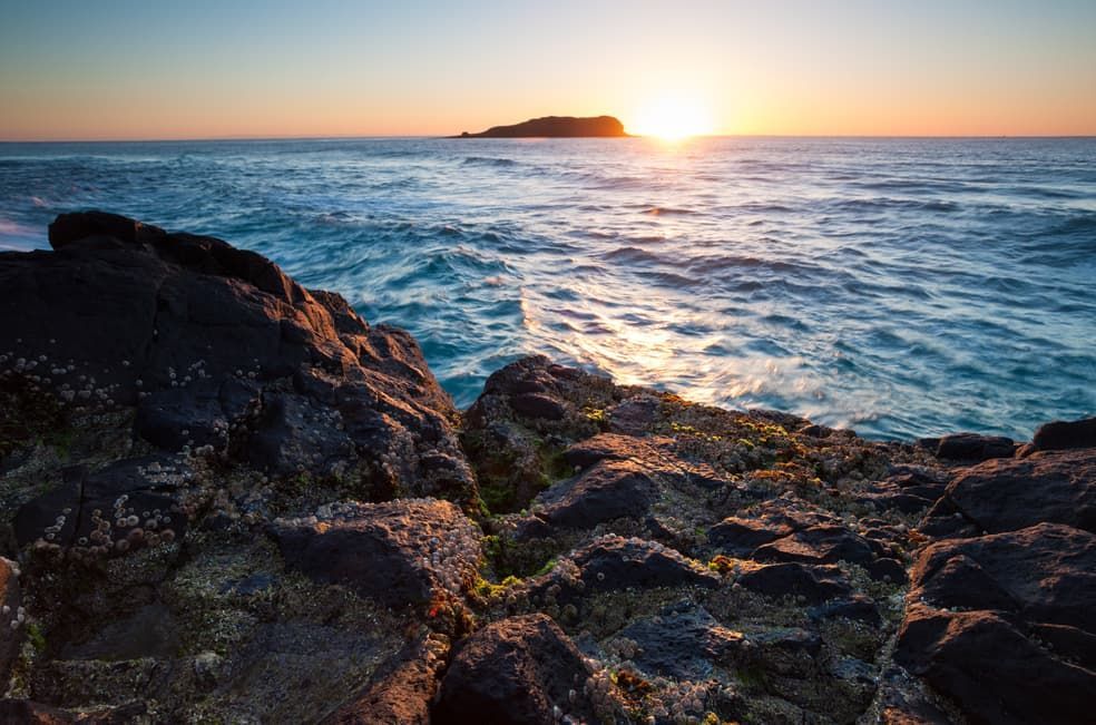 Sunset Over The Ocean, With Rocky Shoreline And A Small Island On The Horizon — Lifestyle Demolition In Tweed Heads, NSW