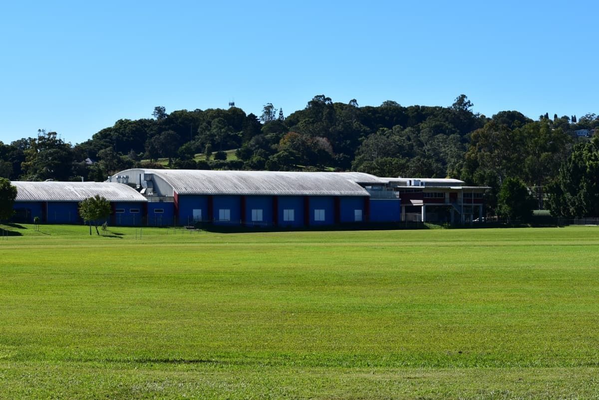 A Large Building Is Sitting in The Middle of A Lush Green Field — Lifestyle Demolition In Lismore, NSW