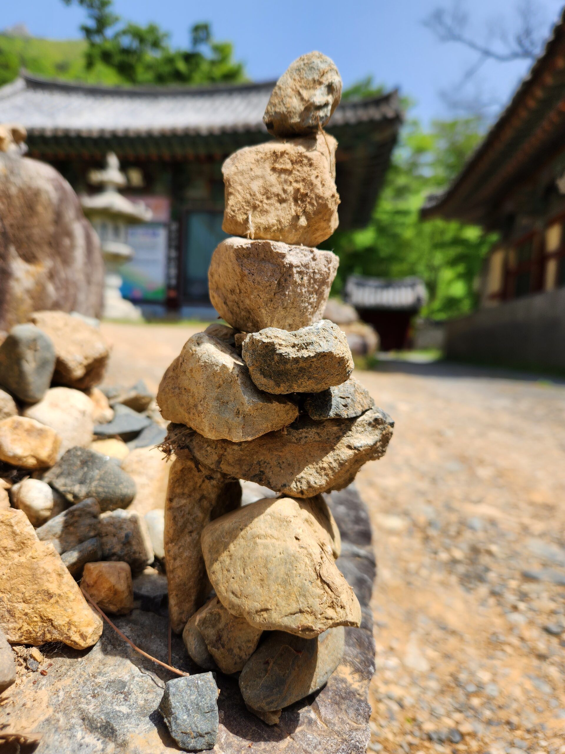 A pile of rocks stacked on top of each other in front of a building.
