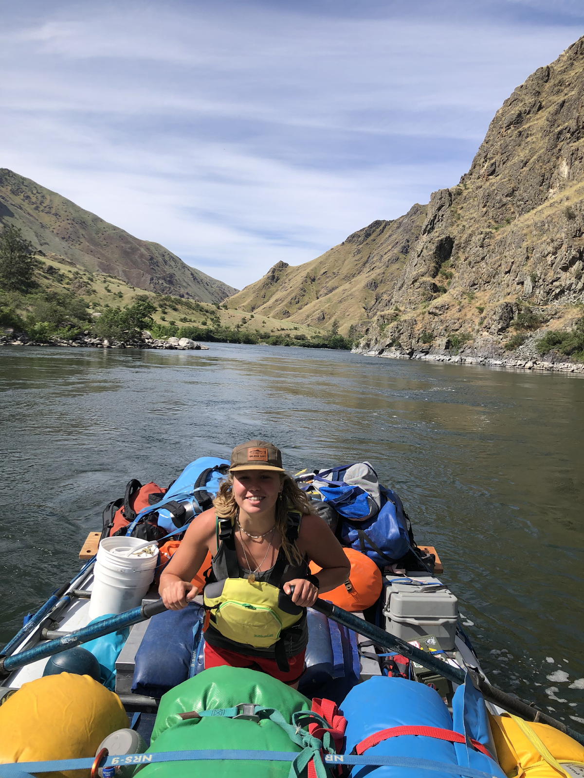 A woman is rowing a raft down a river.