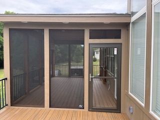 Screened porch with brown frames and door, wooden deck.