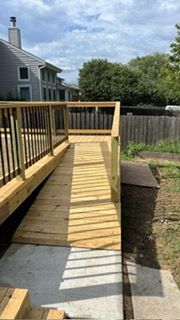 Wooden ramp leading from a deck to a concrete walkway, for accessibility.