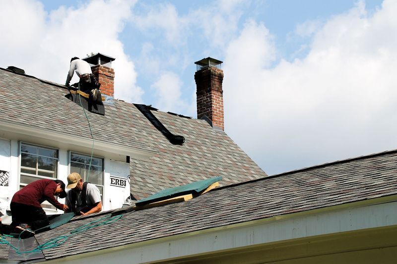 Close-up of a roof with asphalt shingles, gray and brown hues, at an angle.