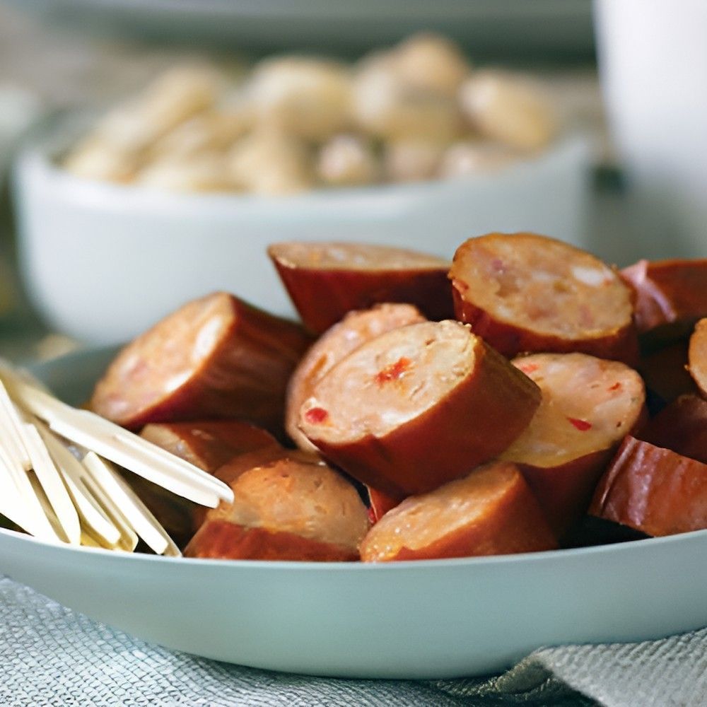 A White Bowl Filled With Sliced Sausages and Cheese Sticks — Corrado & Frank Distributors in Fairy Meadow, NSW