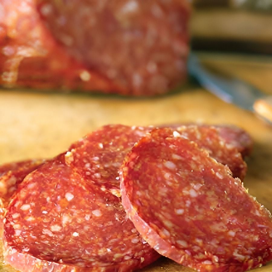 Slices of Pepperoni Are Sitting on a Wooden Cutting Board — Corrado & Frank Distributors in Fairy Meadow, NSW