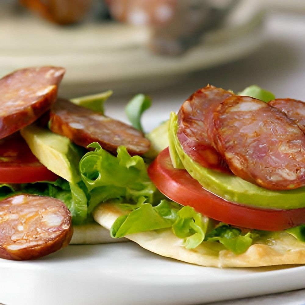A Close Up of a Sandwich With Tomatoes Avocado and Sausage — Corrado & Frank Distributors in Fairy Meadow, NSW