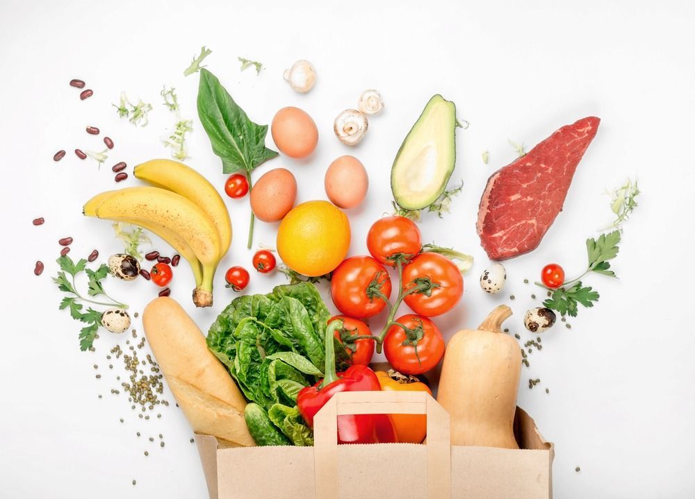 A Paper Bag Filled With Fruits and Vegetables on a White Background — Corrado & Frank Distributors in Fairy Meadow, NSW