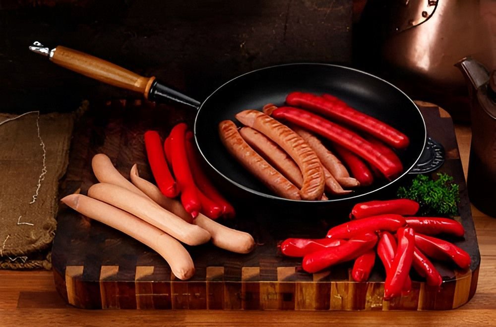 A Frying Pan Filled With Sausages and Red Peppers — Corrado & Frank Distributors in Fairy Meadow, NSW