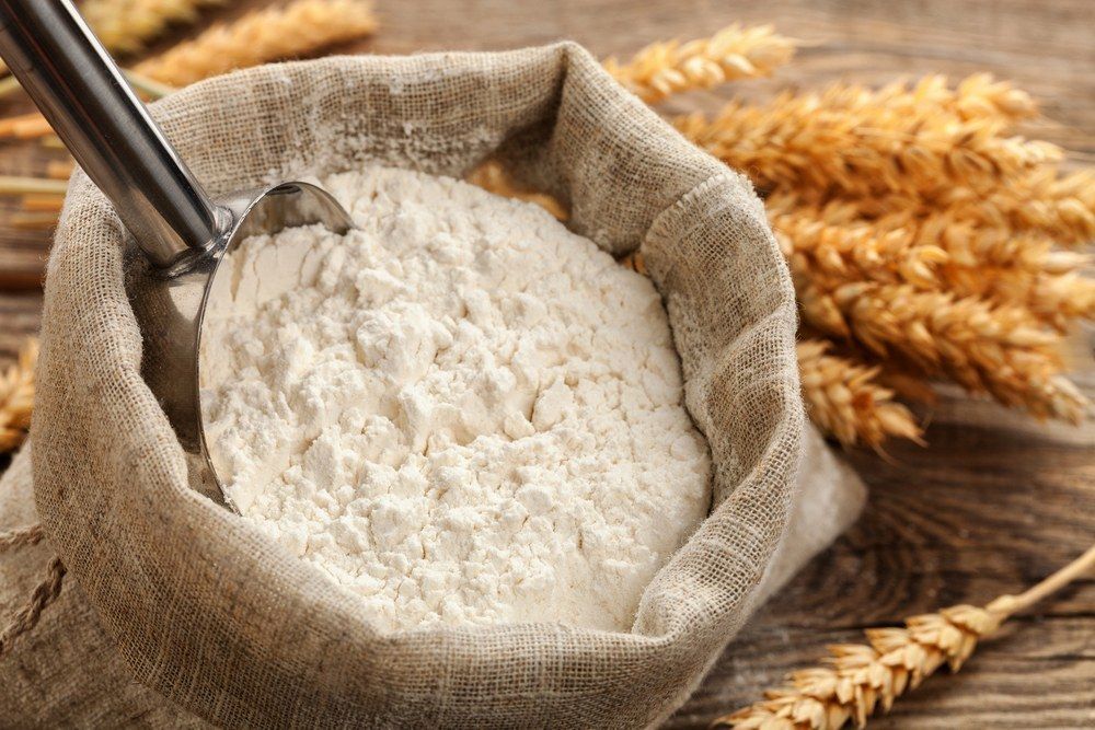 A Bag Of Flour With A Spoon In It On A Wooden Table — Corrado & Frank Distributors in Fairy Meadow, NSW