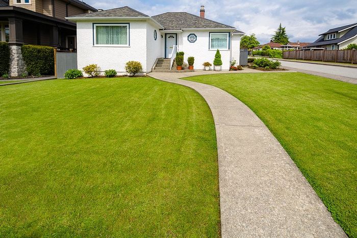 Concrete sidewalk path from the front of a house to the street.