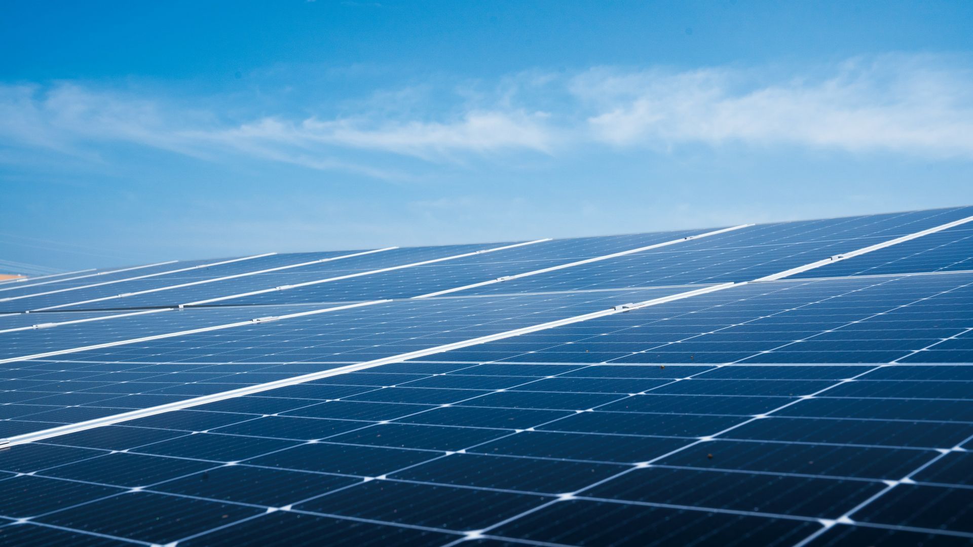 Solar panels stretching across a sunny blue sky landscape