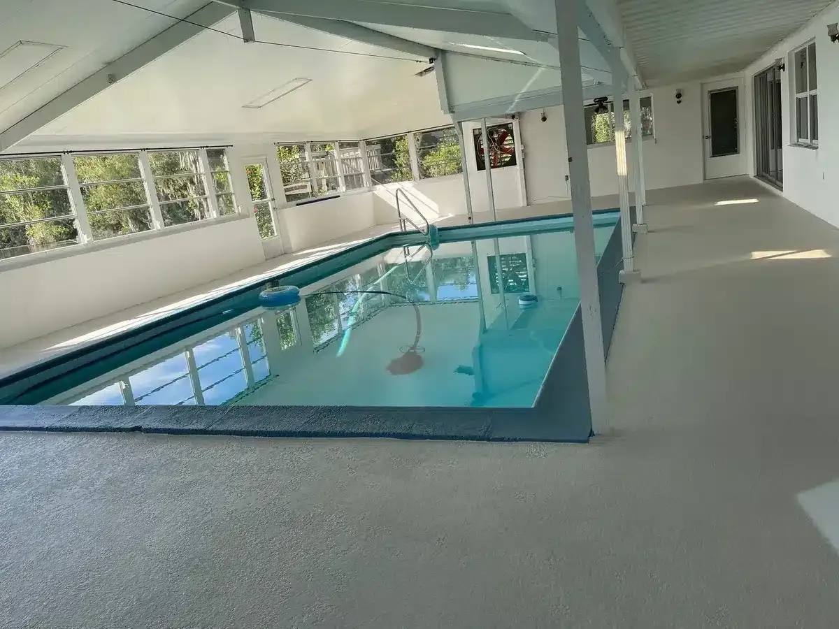 Clear plastic bowl beside a blue bubbling pool or water feature with splashing water.