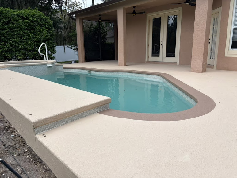 Backyard swimming pool with a beige deck beside a covered patio and house exterior