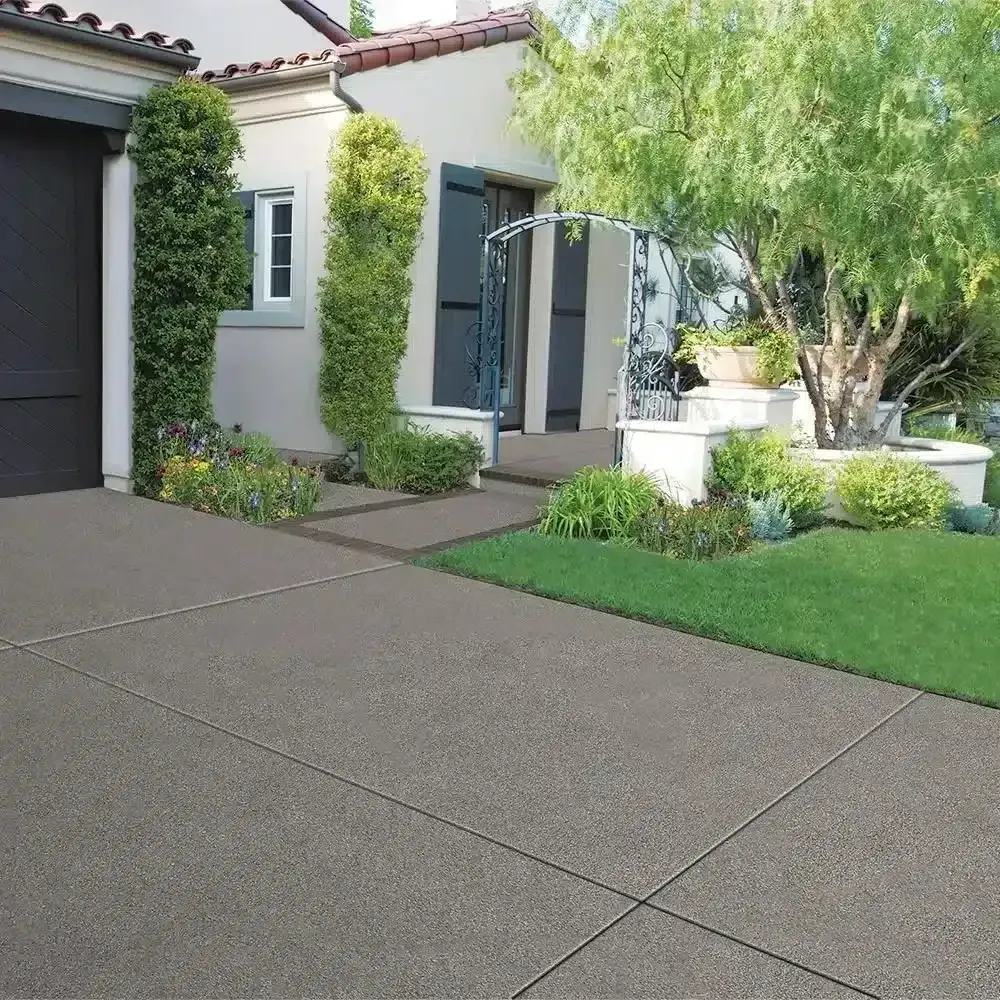 Modern house entry with concrete driveway, front walkway, lush landscaping, and a tree-lined yard