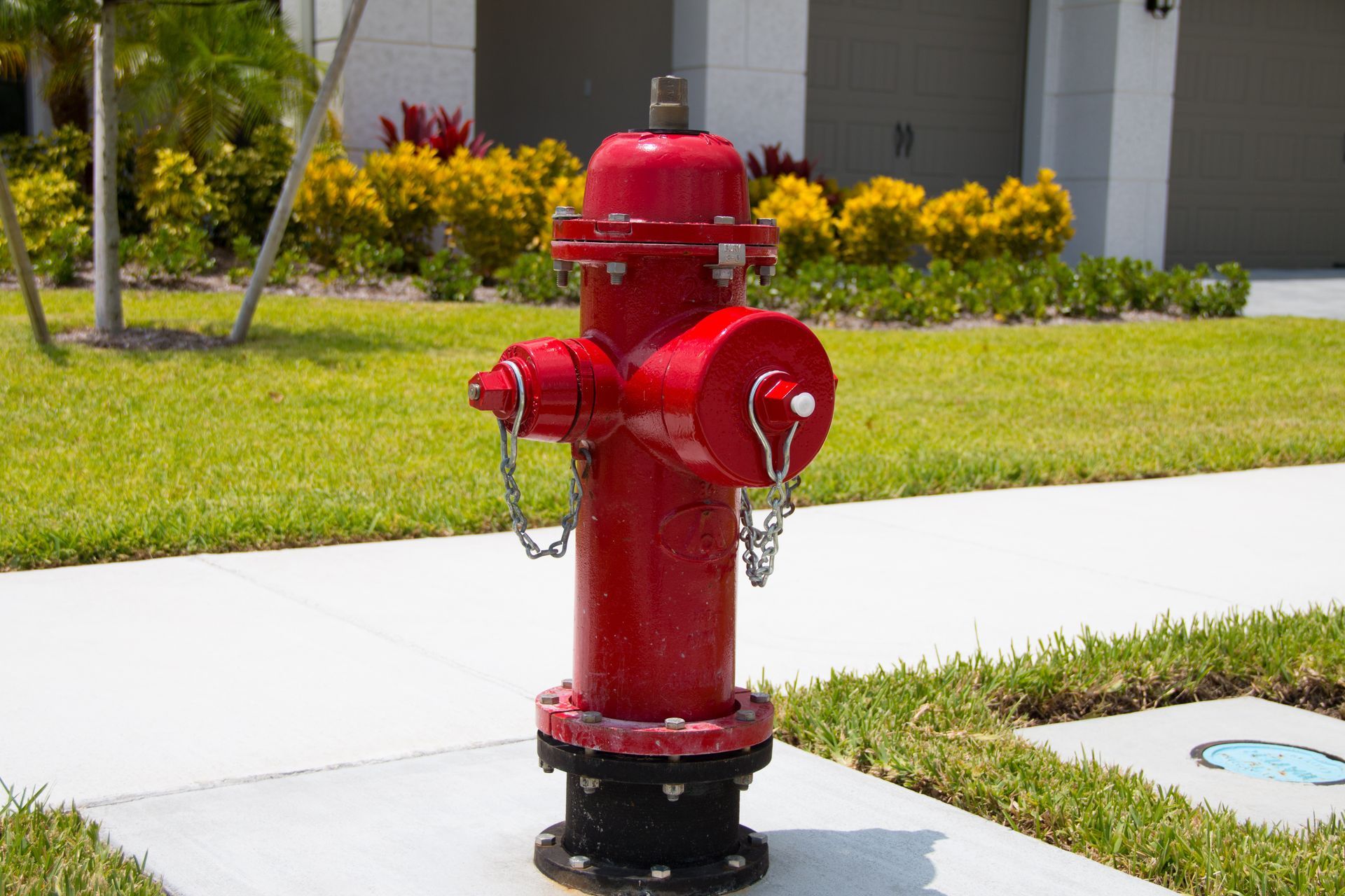 Red fire hydrant installed beside a residential sidewalk for emergency water supply access.