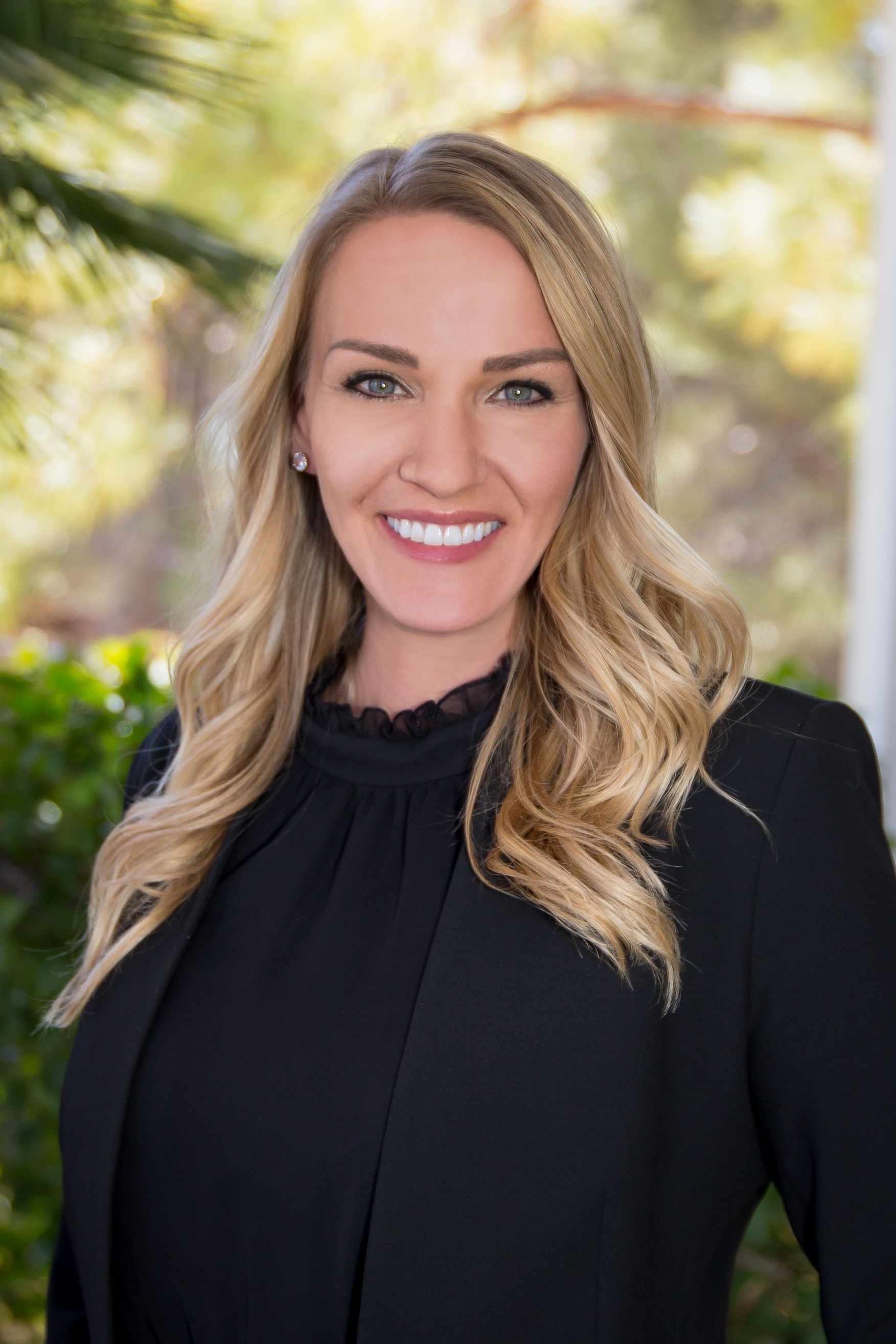 The woman is wearing a black jacket and smiling for the camera.