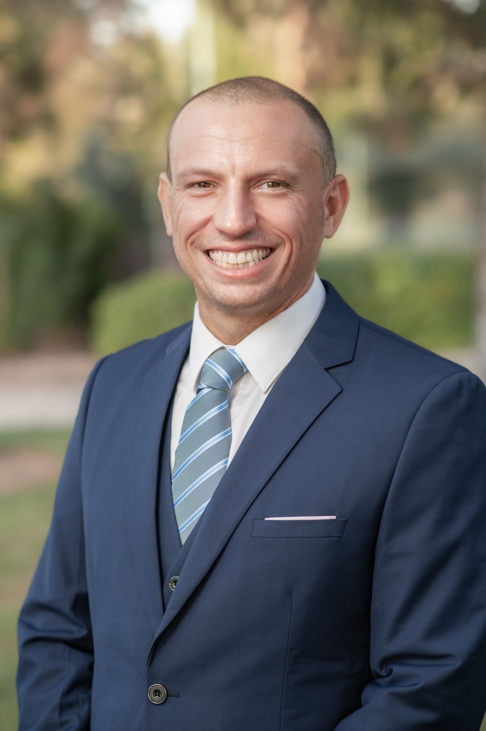 A man in a suit and tie is smiling for the camera.