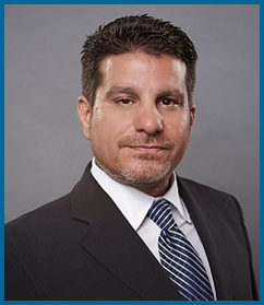 A man in a suit and tie is smiling for the camera