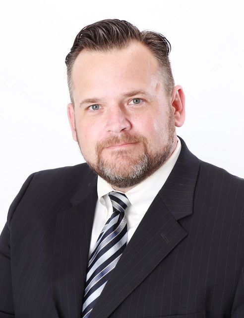 A man with a beard is wearing a suit and tie.