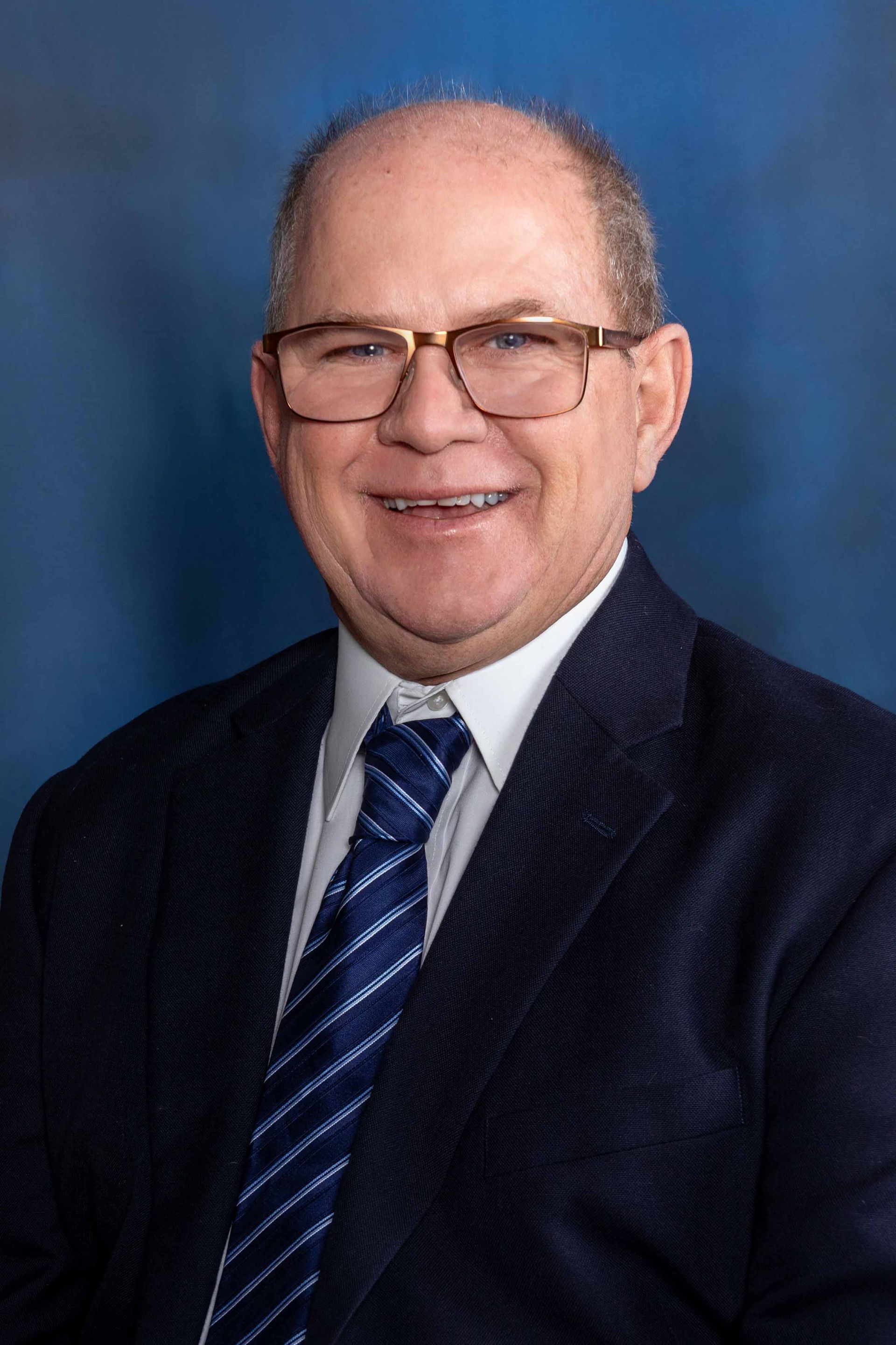 A man in a suit and tie is smiling for the camera.