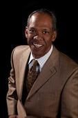 A man in a suit and tie is smiling for the camera.