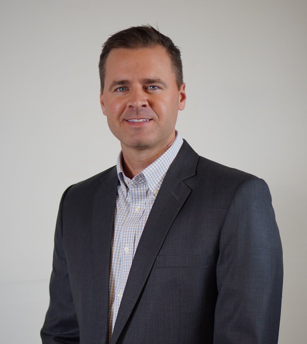 A man in a suit is smiling for the camera