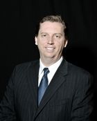 A man in a suit and tie is smiling for the camera.