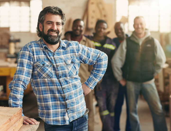 A man in a plaid shirt is standing in front of a group of men.